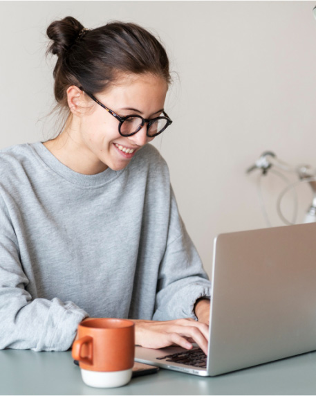 Girl typing on laptop with mug of coffee on the side